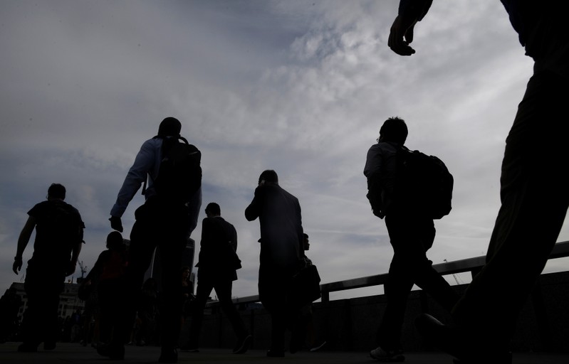 Workers cross London Bridge during the morning rush hour in London