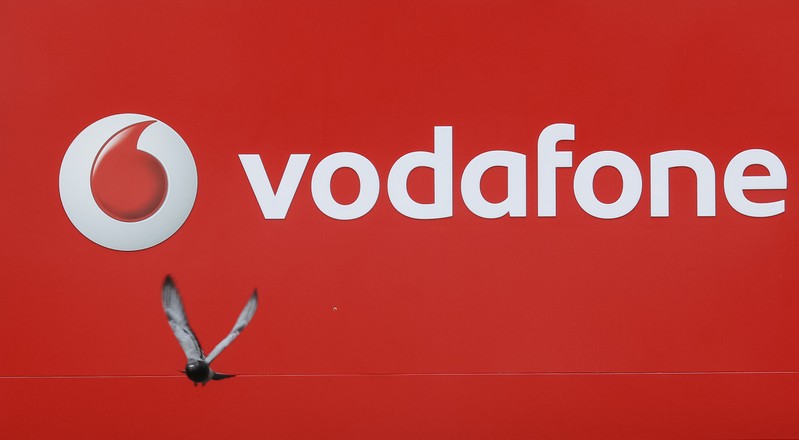 Pigeon flies past the logo of Vodafone in Kiev