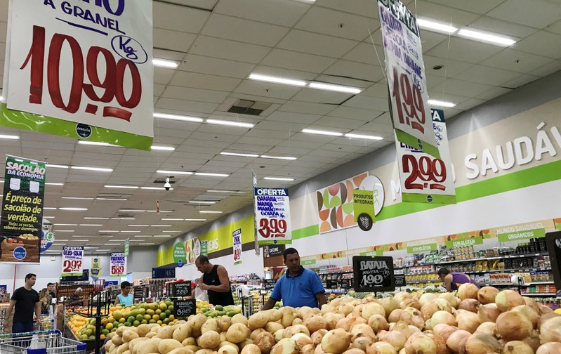 FILE PHOTO: Customers look at the prices at a supermarket in Rio de Janeiro