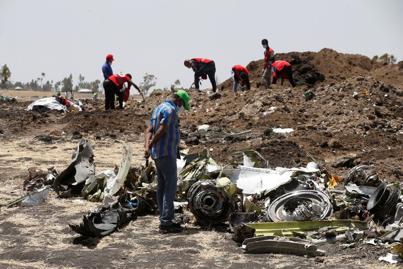 A man watches debris at the scene of the Ethiopian Airlines Flight ET 302 plane crash, near the town of Bishoftu, southeast of Addis Ababa