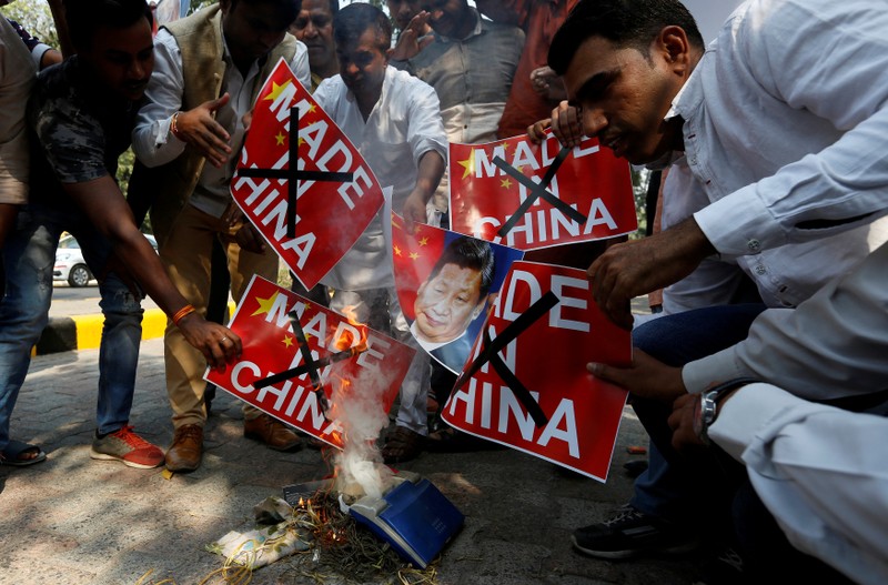 FILE PHOTO: Demonstrators burn Chinese goods and poster of Chinese President Xi, during a protest in New Delhi