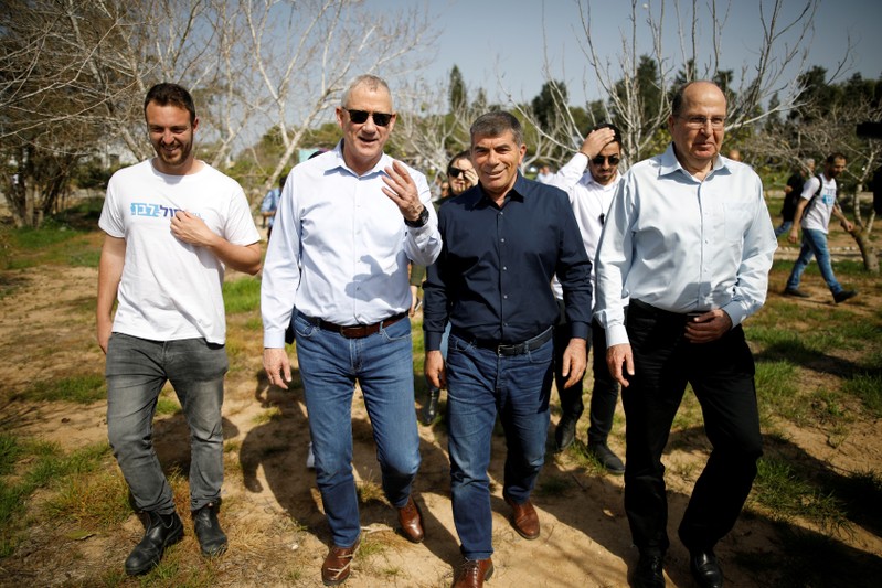 FILE PHOTO: Benny Gantz, head of the Blue and White party, walks with fellow party candidates during a visit to a kibbutz in Israel outside the northern Gaza Strip