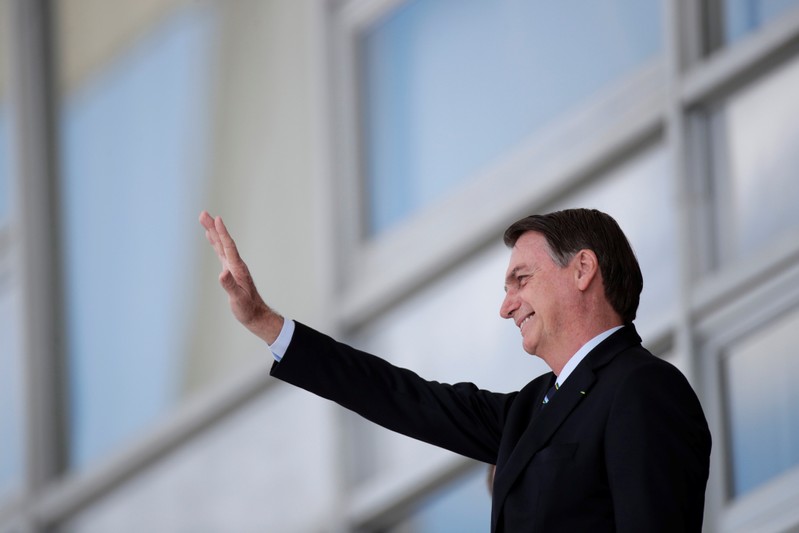 Brazil's President Jair Bolsonaro waves before a meeting with Paraguay's President Mario Abdo at the Planalto Palace in Brasilia