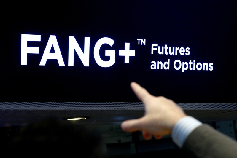 FILE PHOTO - A trader points to a screen that displays FANG+, group of highly-traded technology and tech-enabled companies, on the floor of the NYSE in New York