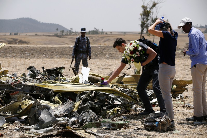 An American family lays flowers for their daughter, who died in the Ethiopian Airlines Flight ET 302 plane crash, after a commemoration ceremony at the scene of the crash, near the town of Bishoftu, southeast of Addis Ababa
