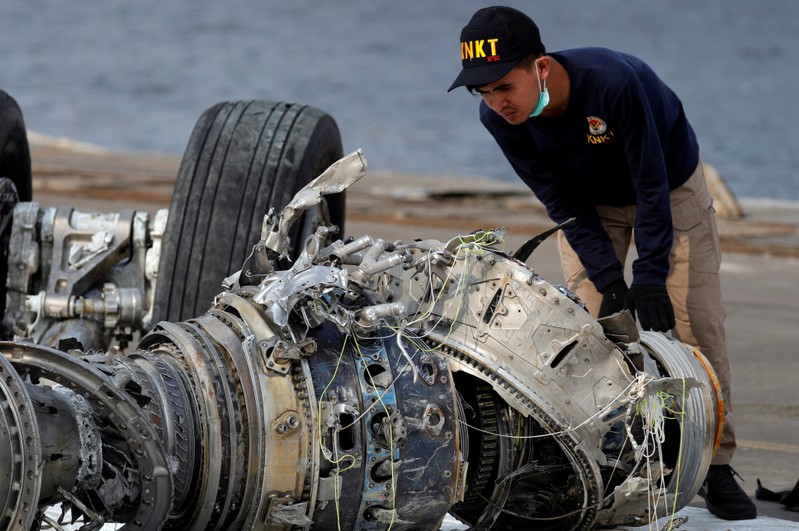 An Indonesian National Transportation Safety Commission (KNKT) official examines a turbine engine from the Lion Air flight JT610 at Tanjung Priok port in Jakarta