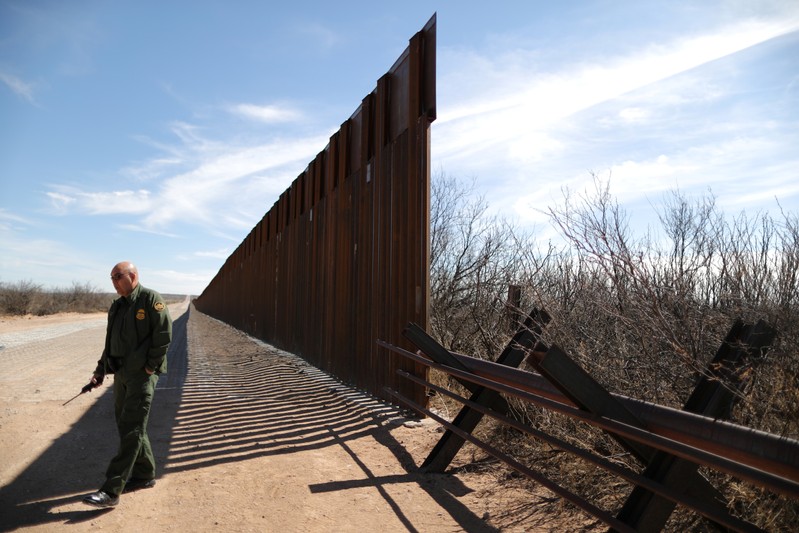 Supervisory Border Patrol Agent Joe Romero walks next to new bollard-style U.S.-Mexico border fencing in Santa Teresa