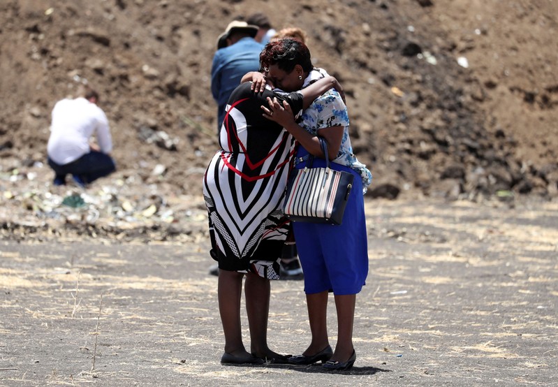 United Nations workers mourn their colleagues during a commemoration ceremony for the victims at the scene of the Ethiopian Airlines Flight ET 302 plane crash, near the town Bishoftu