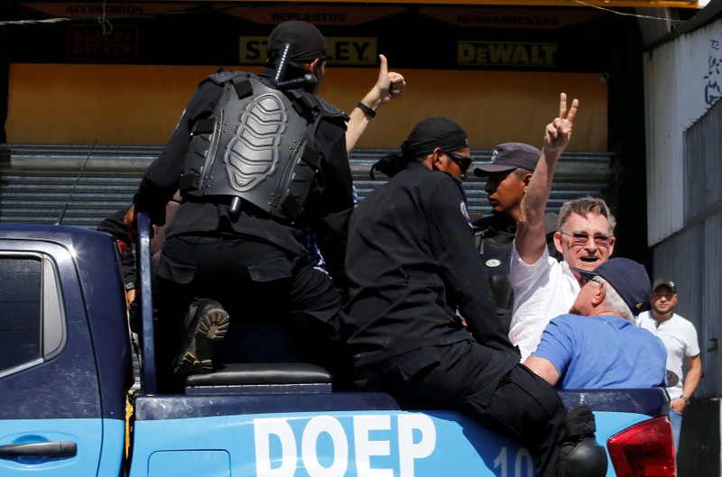 A demonstrator gestures as he is detained by riot police during a protest against the government of Nicaragua's President Daniel Ortega in Managua