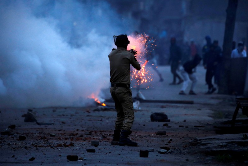 FILE PHOTO: Indian police officer fires tear gas shell towards demonstrators in Srinagar