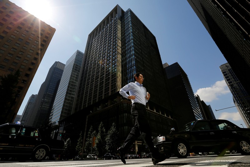 FILE PHOTO - A man runs on a crosswalk at a business district in central Tokyo