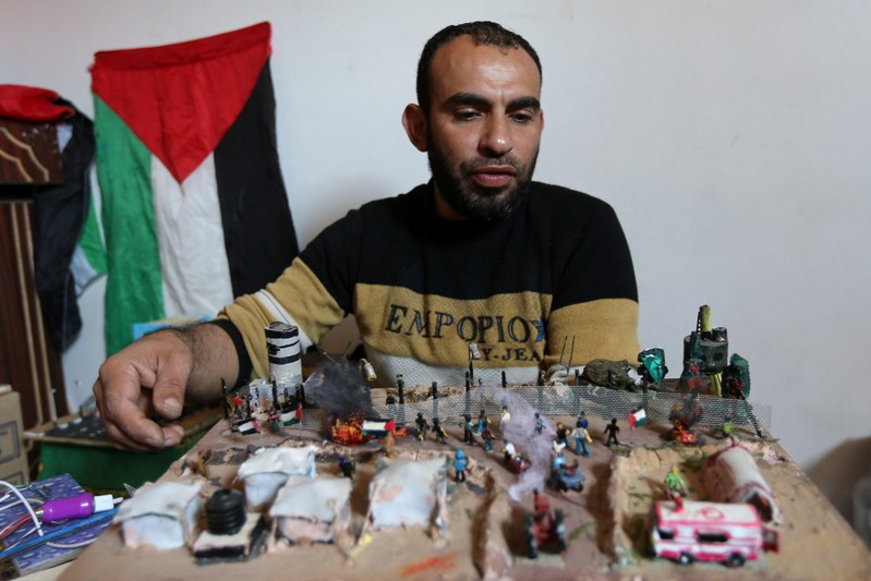 Palestinian diorama artist Majdi Abu Taqeya works on miniature figures he carves from remnants of Israeli ammunition collected from the scenes of border protests along the Israel-Gaza border, in the central Gaza Strip