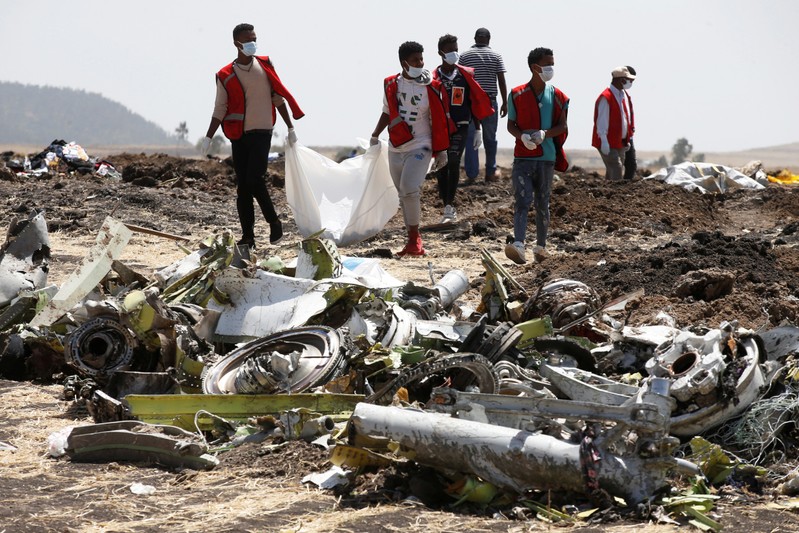 Ethiopian Red Cross workers carry a body bag with the remains of Ethiopian Airlines Flight ET 302 plane crash victims at the scene of a plane crash, near the town of Bishoftu, southeast of Addis Ababa