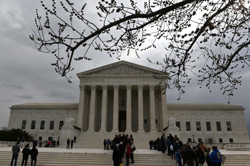 FILE PHOTO: People wait in line outside the U.S. Supreme Court to hear the orders being issued, in Washington