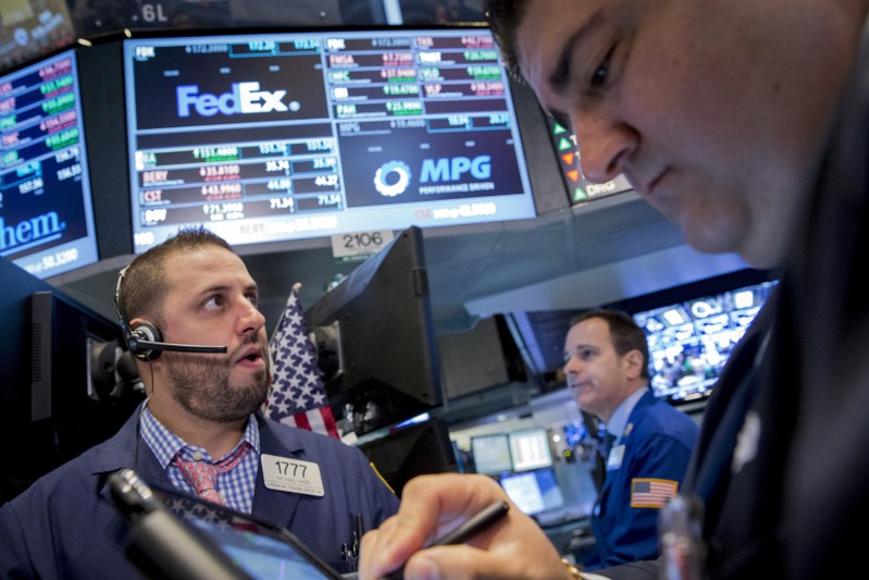 FILE PHOTO: Traders work at the post that trades FedEx on the floor of the New York Stock Exchange