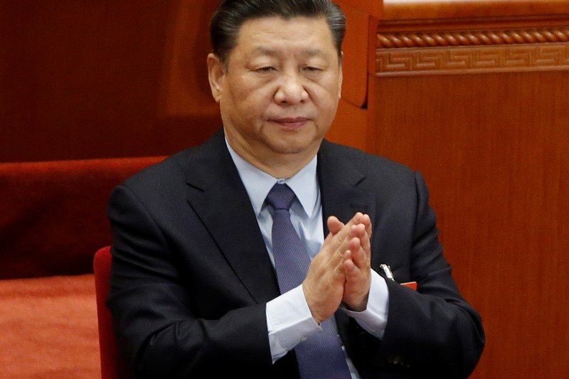 Chinese President Xi Jinping claps at the closing session of the National People's Congress (NPC) at the Great Hall of the People in Beijing