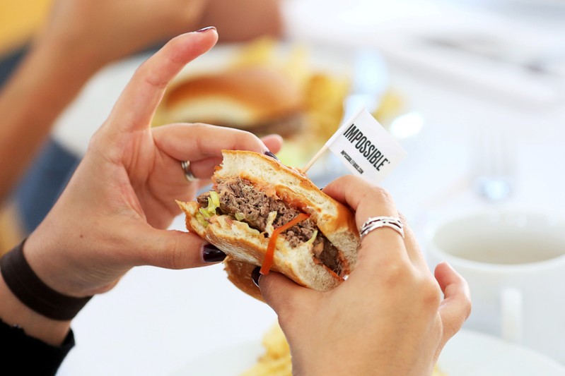 FILE PHOTO: Journalists taste test the plant-based hamburgers during a media tour of Impossible Foods labs and processing plant in Redwood City, California