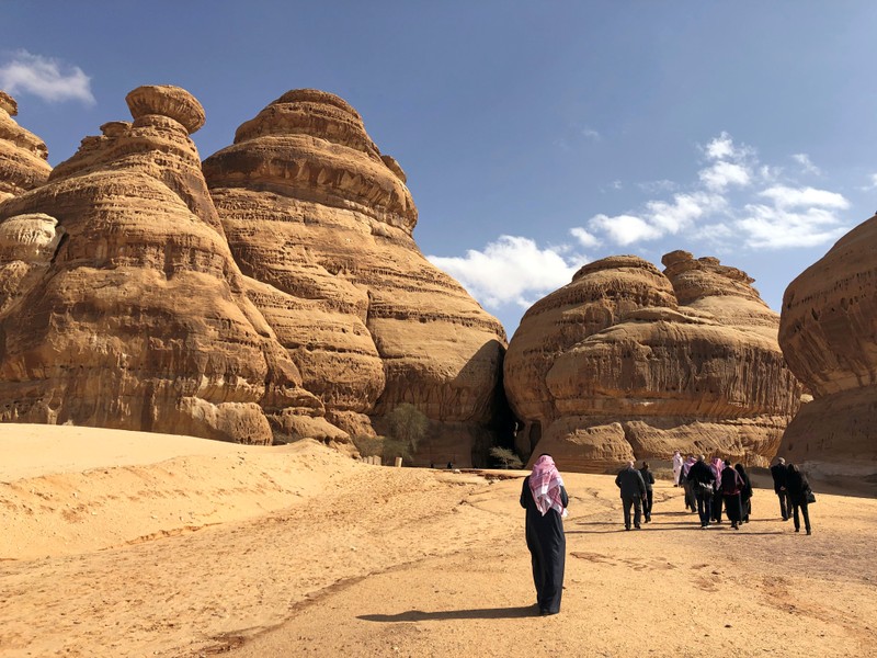 Visitors walk outside the tombs at the Madain Saleh antiquities site, al-Ula