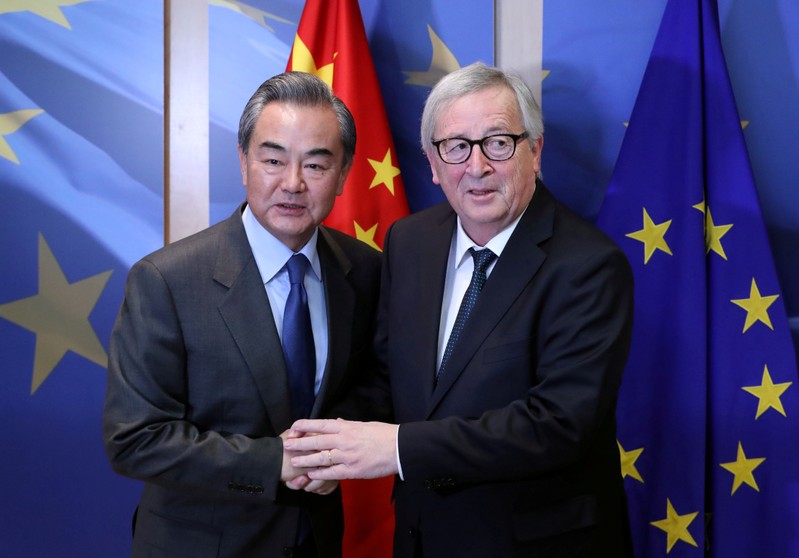 FILE PHOTO: Chinese Foreign Minister Wang Yi is welcomed by European Commission President Jean-Claude Juncker ahead of a meeting in Brussels