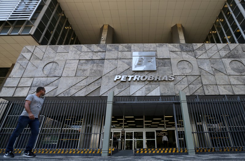FILE PHOTO: A man walks in front of the Brazil's state-run Petrobras oil company headquarters in Rio de Janeiro