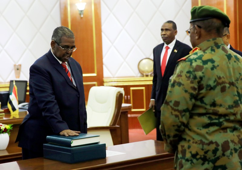 Mohamed Tahir Ayala is sworn in as prime minister in front of Sudan's President Omar al-Bashir during a swearing in ceremony in Khartoum