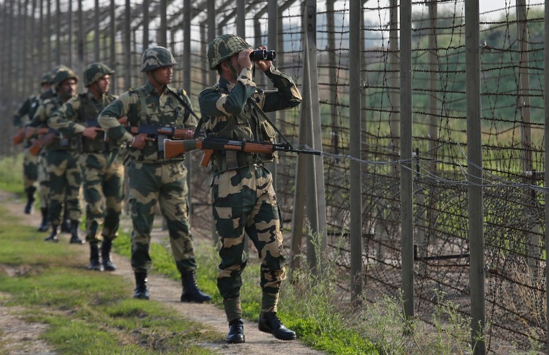 FILE PHOTO: India's Border Security Force soldiers patrol along the fenced border with Pakistan in Ranbir Singh Pura sector