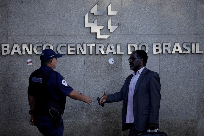 FILE PHOTO: People walk outside the central bank headquarters building in Brasilia