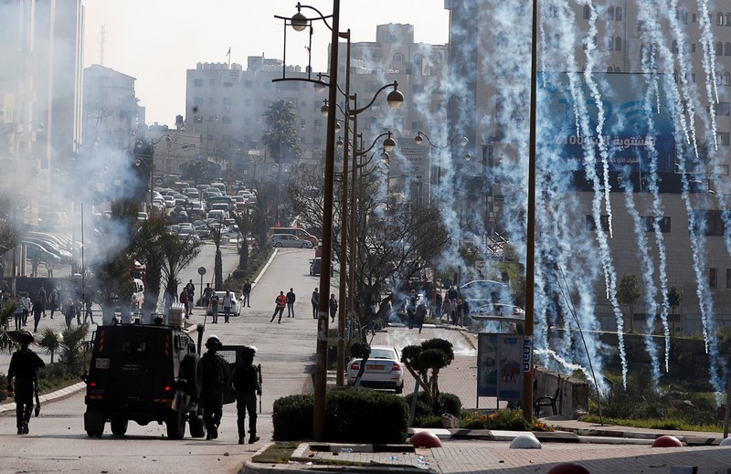 Israeli forces fire tear gas canisters at Palestinian protesters during clashes near the Jewish settlement of Beit El, in the Israeli-occupied West Bank