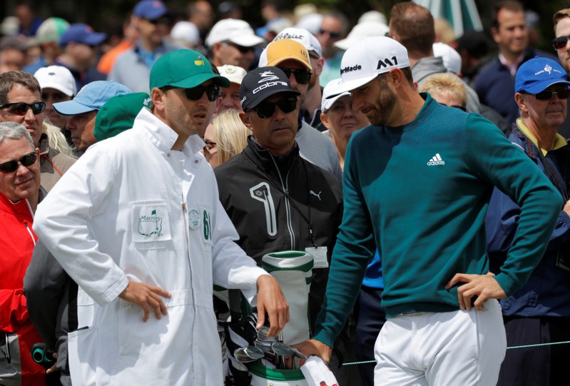 FILE PHOTO: Dustin Johnson of the U.S. stands on the putting green before withdrawing from the 2017 Masters in Augusta
