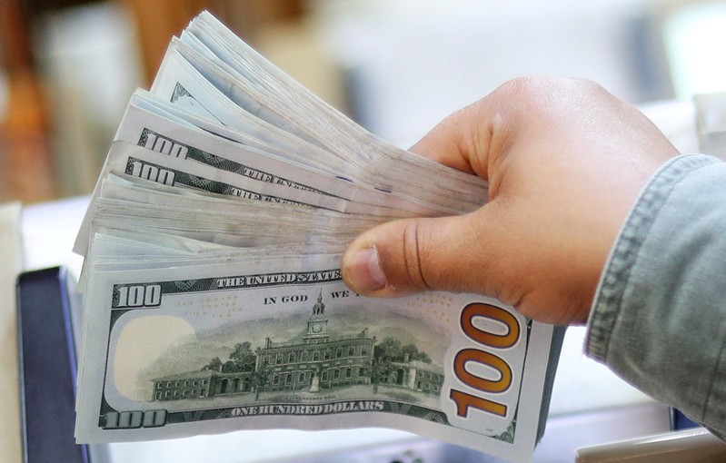 An employee counts U.S. dollar bills at a money exchange office in central Cairo