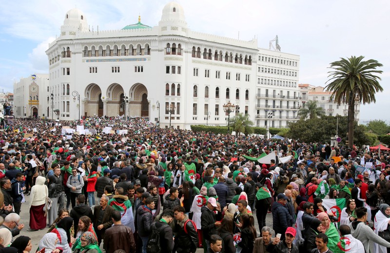 FILE PHOTO: People carry national flags and banners during a protest calling on President Abdelaziz Bouteflika to quit, in Algiers