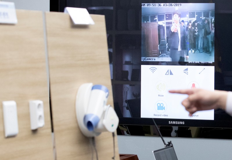 A police officer demonstrates a subminiature spycam installed inside a hairdryer which is used to film guests illicitly at a motel, in Seoul
