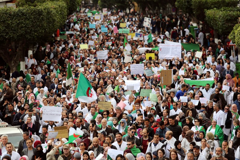 FILE PHOTO: Health workers carry national flags and banners as they march during a protest calling on President Abdelaziz Bouteflika to quit, in Algiers