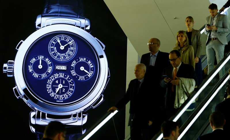 Visitors are seen in front of a display of Swiss watch manufacturer Patek Philippe at the Baselworld watch and jewellery fair in Basel