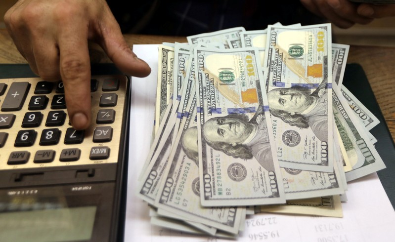 An employee counts U.S. dollar bills at a money exchange office in central Cairo