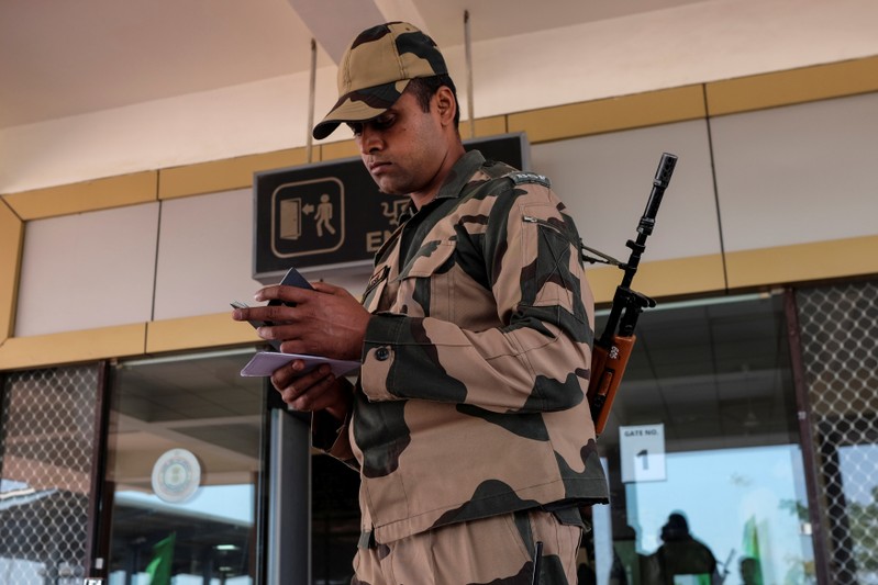 BSF soldier checks the passport of an Indian passenger from the 'friendship bus' between Indian and Pakistan at the Wagah-Attari border crossing