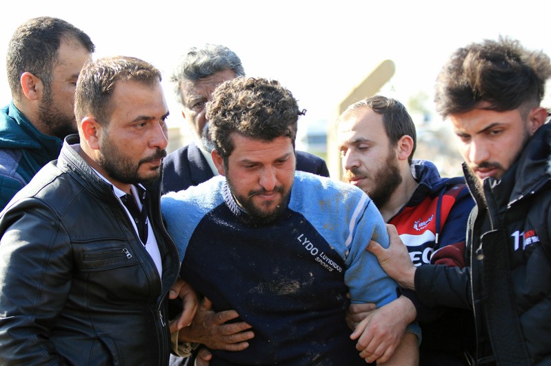 A relative of one of the victims who died after an overloaded ferry sank in Tigris river near Mosul, cries during his funeral at Mosul cemetery