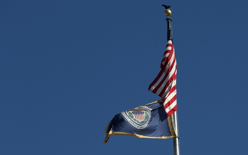 Flags are pictured at the top of Federal Reserve Board building on Constitution Avenue in Washington
