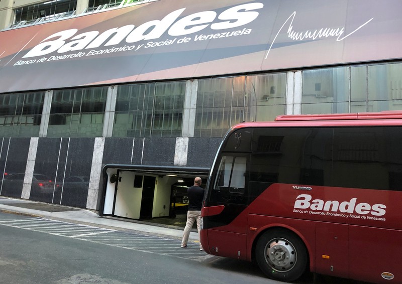A man stands outside the Bandes bank headquarters in Caracas