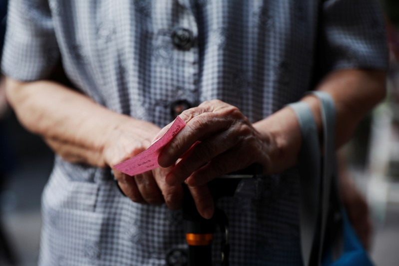 A voter waits at a polling station to cast their vote in the general election in Bangkok