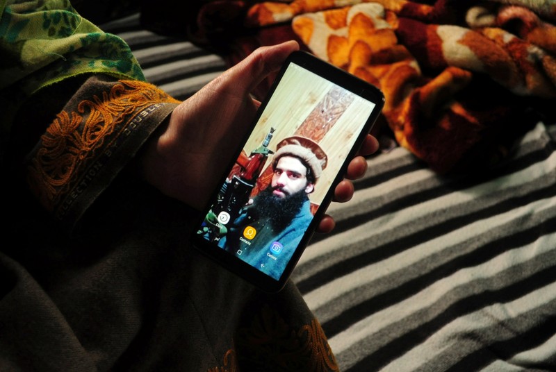 Sister of Owais Malik, a suspected militant, displays her phone with the picture of Malik, at her home in south Kashmir's Kulgam district