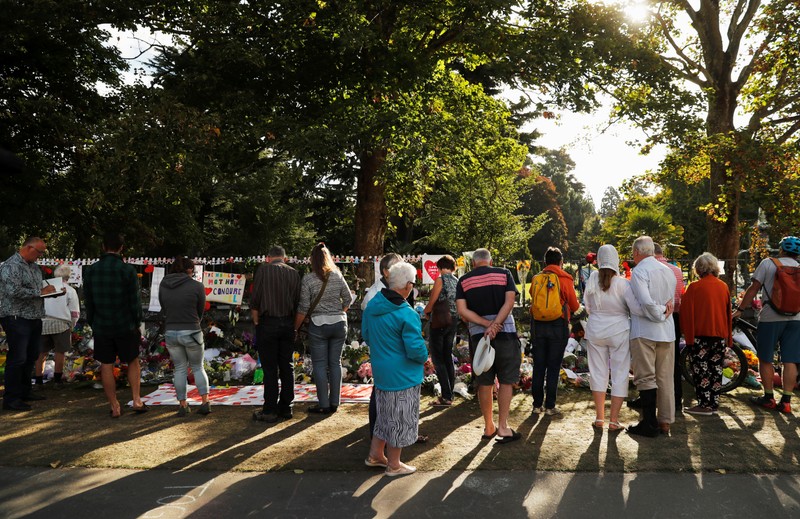 People visit a memorial site for victims of Friday's shooting, in front of Christchurch Botanic Gardens in Christchurch