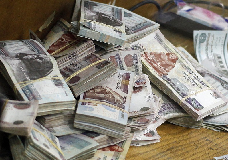 Stacks of money are pictured as an employee counts them at a bank in Cairo