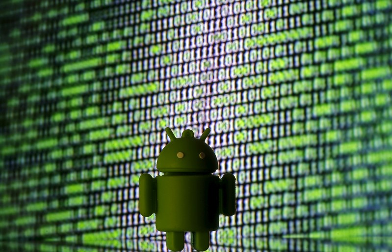 3D printed Android logo is seen in front of a displayed cyber code