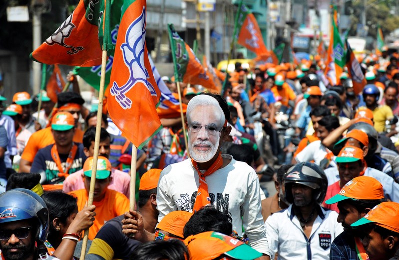 A Bharatiya Janata Party (BJP) supporter wears a mask of Prime Minister Narendra Modi, after BJP won complete majority in Tripura Assembly elections, during a victory celebration rally in Agartala
