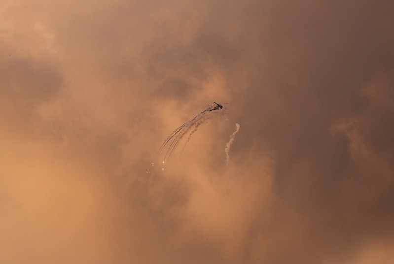 An Israeli Apache helicopter releases flares as it flies over the Gaza Strip