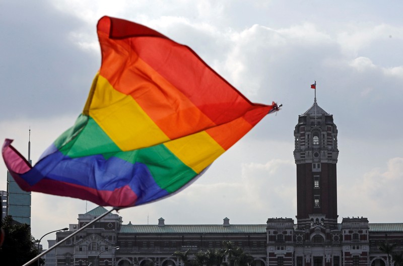 FILE PHOTO: A participant waves a rainbow flag in front of President's office building during LGBT pride parade in Taipei