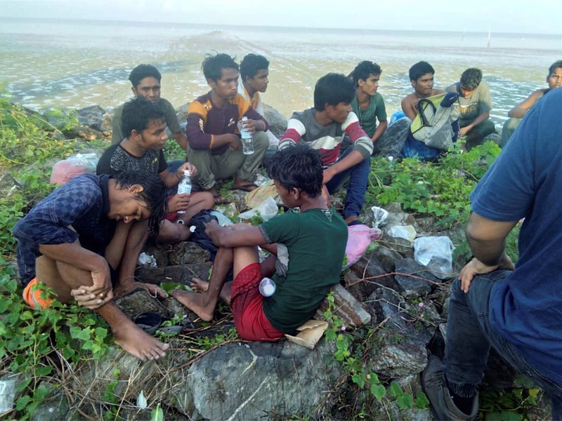 Dozens of people, believed to be Rohingya Muslims from Myanmar who were dropped off from a boat are pictured on a beach near Sungai Belati, Perlis, Malaysia