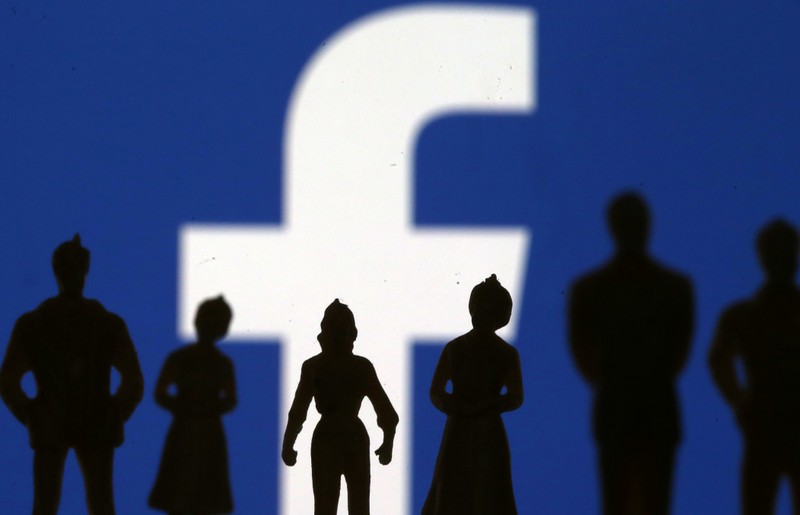 FILE PHOTO - Small toy figures are seen in front of Facebook logo in this illustration picture