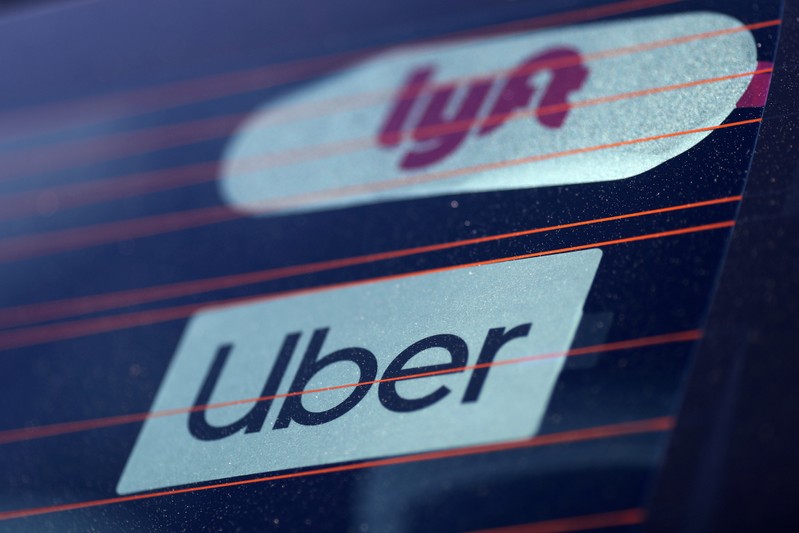 FILE PHOTO: Uber and Lyft signs are seen on a car in Redondo Beach